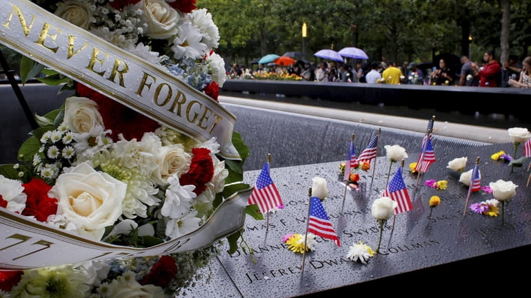 Flowers and American flags are seen at the National September...