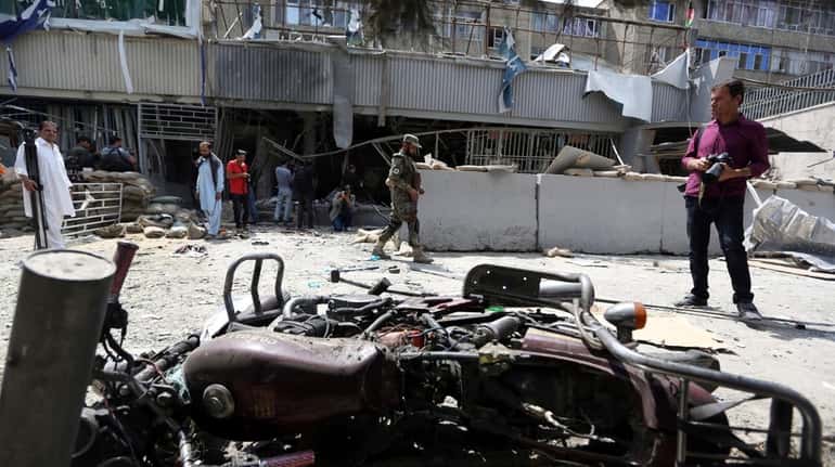 Debris litters the front of Kabul Bank after a suicide...