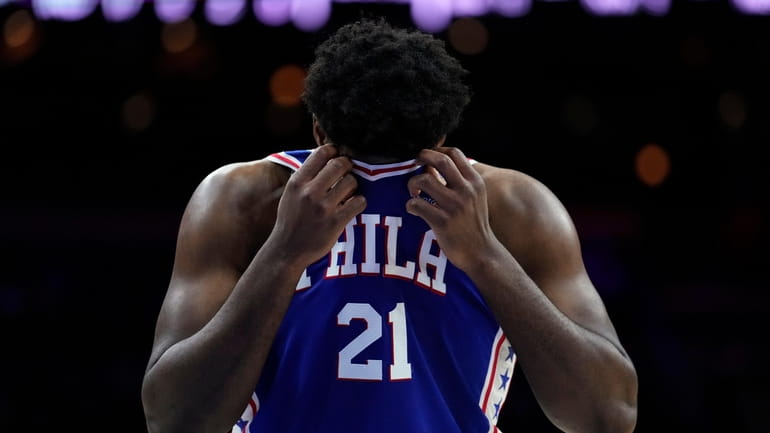 Philadelphia 76ers' Joel Embiid wipes his face during the first...