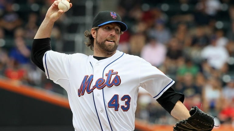 R.A. Dickey #43 of the New York Mets delivers a...
