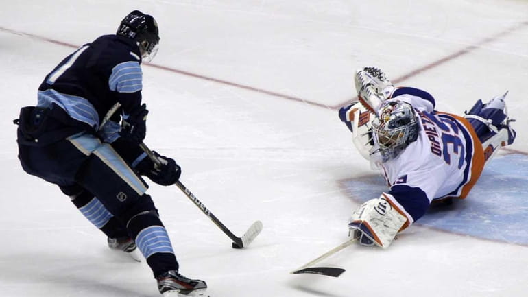 Pittsburgh Penguins' Evgeni Malkin, left, beats New York Islanders goalie...