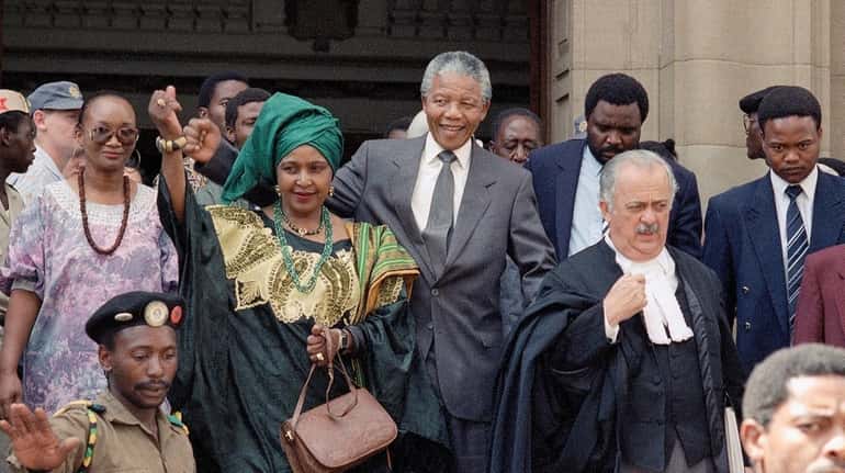 Winnie Mandela, and husband, Nelson Mandela, walk out of court...
