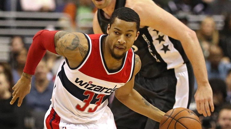 Trey Burke of the Wizards dribbles up the court against...