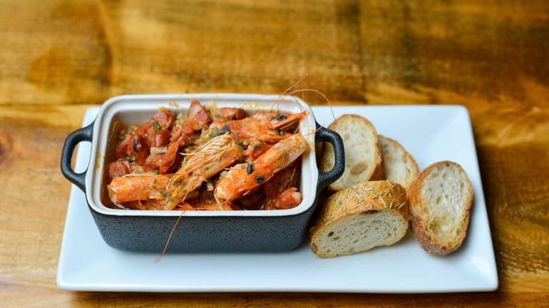 Shrimp heads served in a spicy sauce with chorizo is...