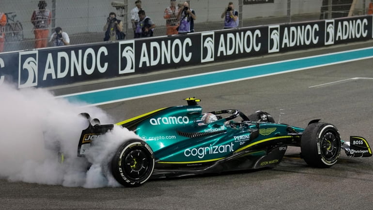 Aston Martin driver Sebastian Vettel of Germany burns the tires...