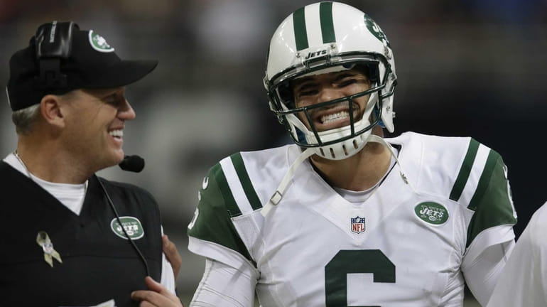 Mark Sanchez smiles as he talks with Rex Ryan after...
