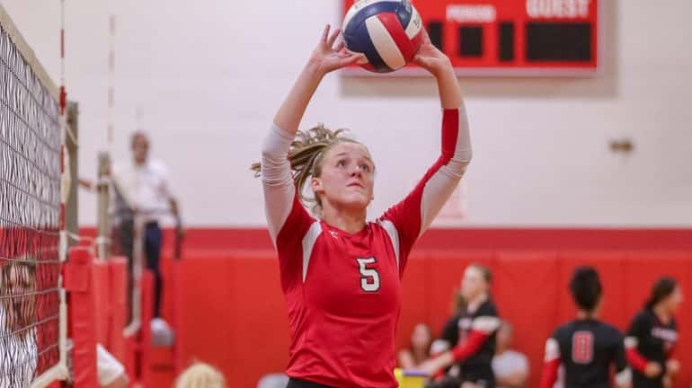 Caitlin Dellecave of Patchogue-Medford sets the ball during a volleyball...