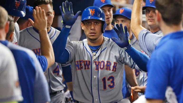The Mets' Asdrubal Cabrera celebrates with teammates after hitting a...