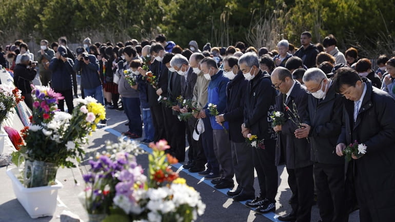 People observe a moment of silence at 2:46 p.m., the...