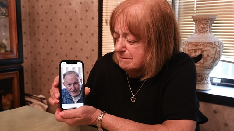 Carol Riggs shows a cellphone photo of late husband Richard Riggs in...