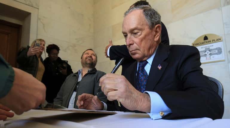 Former New York City Mayor Michael Bloomberg fills out paperwork...