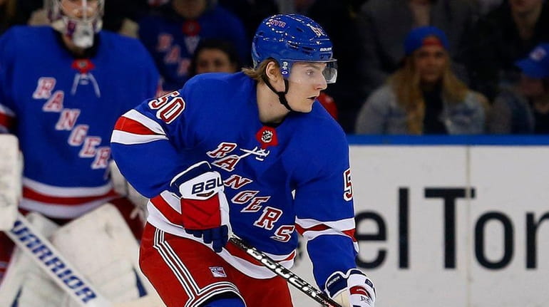 Lias Andersson #50 of the Rangers controls the puck against...