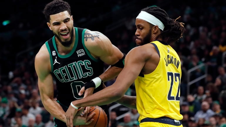 Boston Celtics' Jayson Tatum (0) is defended by Indiana Pacers'...
