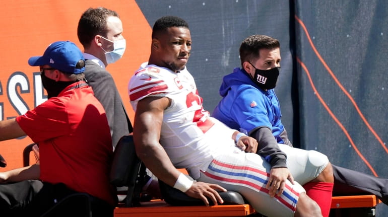 Giants running back Saquon Barkley is carted to the locker room...