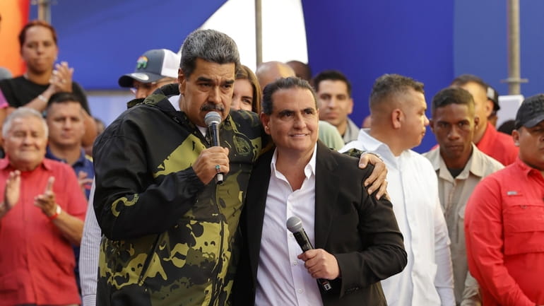 Venezuela's President Nicolas Maduro and Alex Saab stand in an...
