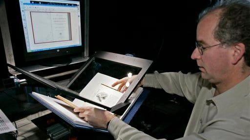 Internet Archive founder Brewster Kahle prepares a book for digital...