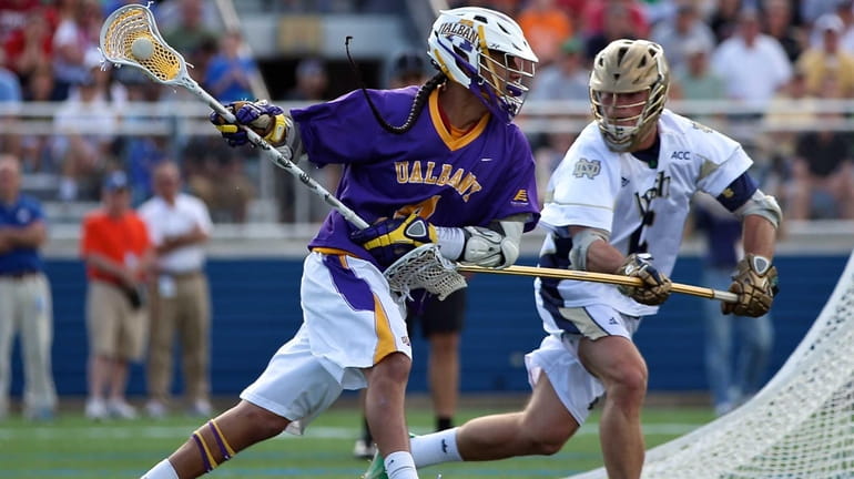 Albany's Lyle Thompson moves around the net against Notre Dame's...