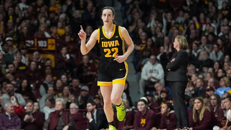 Iowa guard Caitlin Clark (22) points after an Iowa basket...