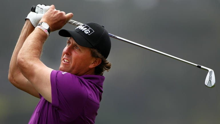 Phil Mickelson watches his tee shot on the fifth hole...