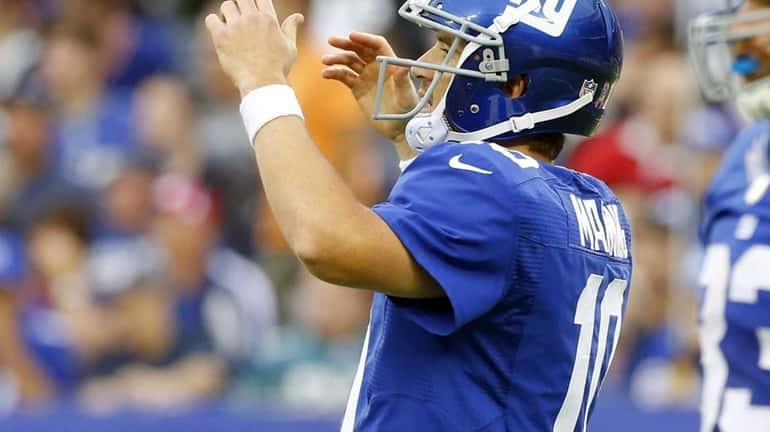 Giants quarterback Eli Manning reacts after throwing an incomplete past...