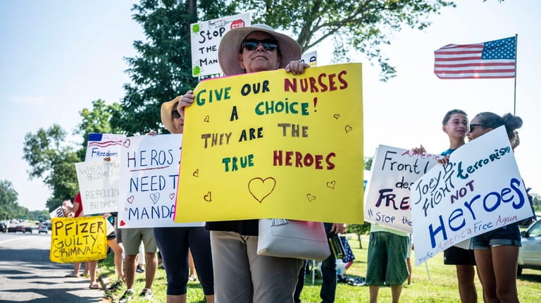 Health care workers protest against being forced to get the...