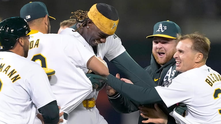 Oakland Athletics' Lawrence Butler, center, celebrates with teammates after hitting...
