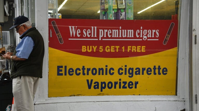 Signs advertising electronic cigarettes, vaporizers, and other tobacco products are...