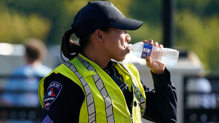 A police officer directing traffic takes a break to drink...
