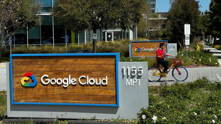 A person rides past the Google sign outside the Google...