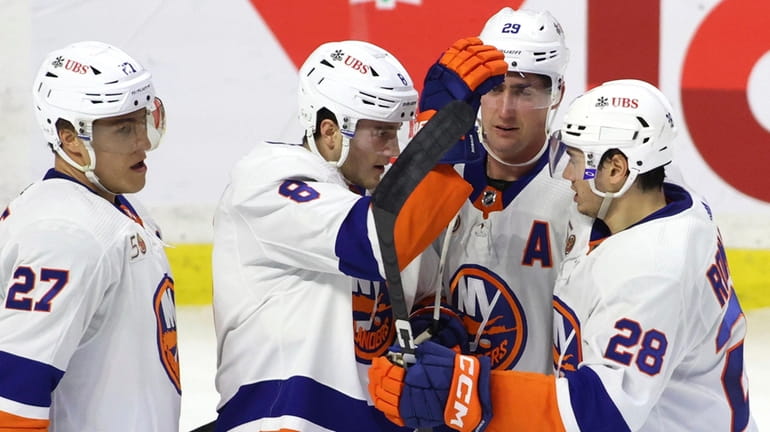 Islanders defenseman Noah Dobson celebrates his goal with teammates Anders...