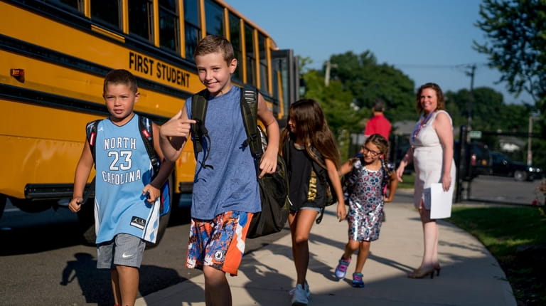 Students get off the bus Wednesday at Robert Seaman Elementary School in...
