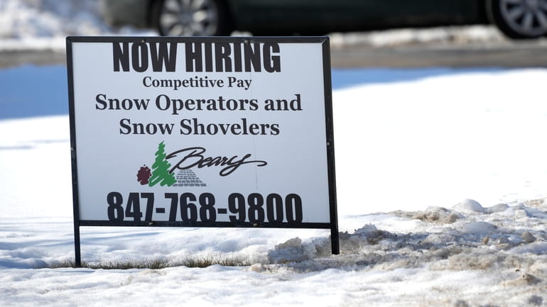 A hiring sign is displayed in Arlington Heights, Ill. on...