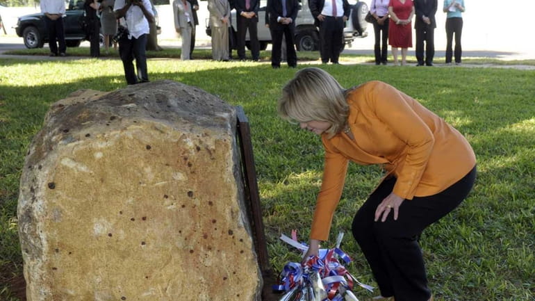 U.S. Secretary of State Hillary Rodham Clinton lays flowers in...