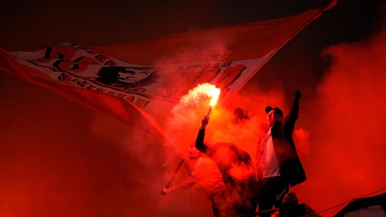 Fans light flares on the stands during the French League...