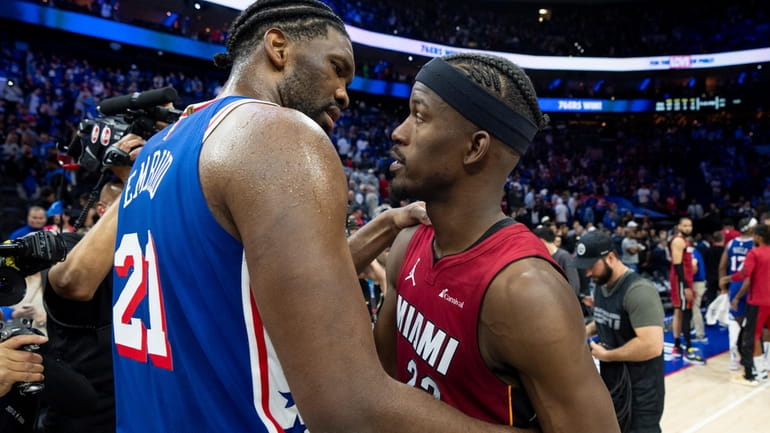 Philadelphia 76ers' Joel Embiid, left, talks with Miami Heat's Jimmy...