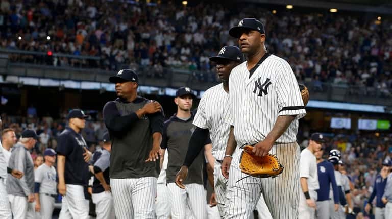 CC Sabathia #52 of the New York Yankees walks to...