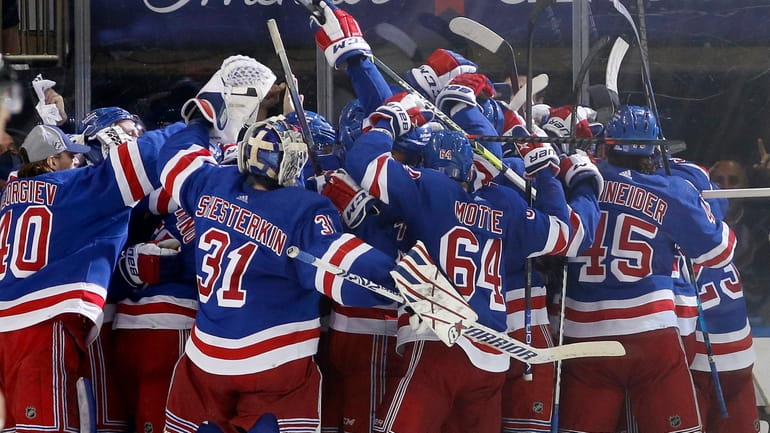 The Rangers celebrate their overtime win against the Penguins in...