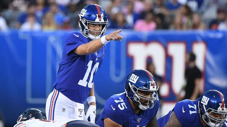 Giants quarterback Eli Manning gestures during the first half of...