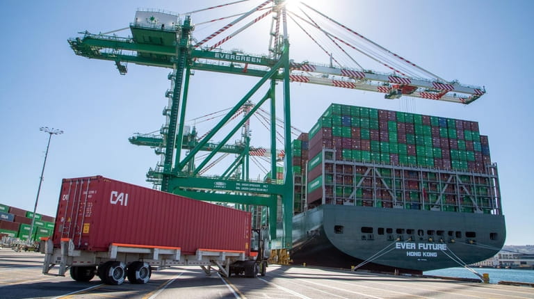 Workers load and unload containers in the Port of Los...