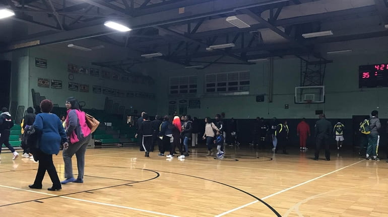 Spectators leave the Wyandanch High School gymnasium after a brawl in...