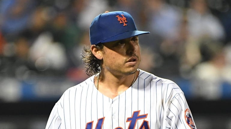 Mets starting pitcher Jason Vargas walks to the dugout after...