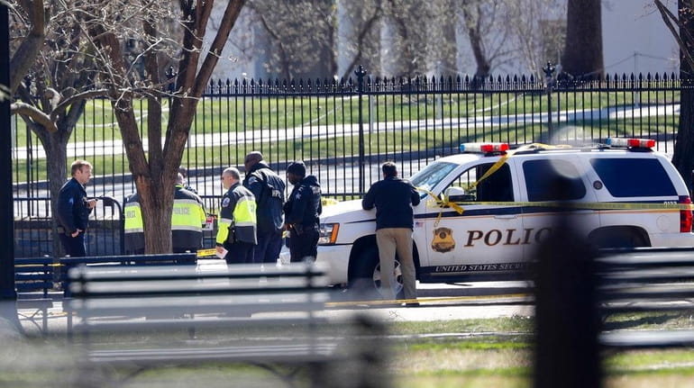 Law enforcement officers gather in front of the White House...