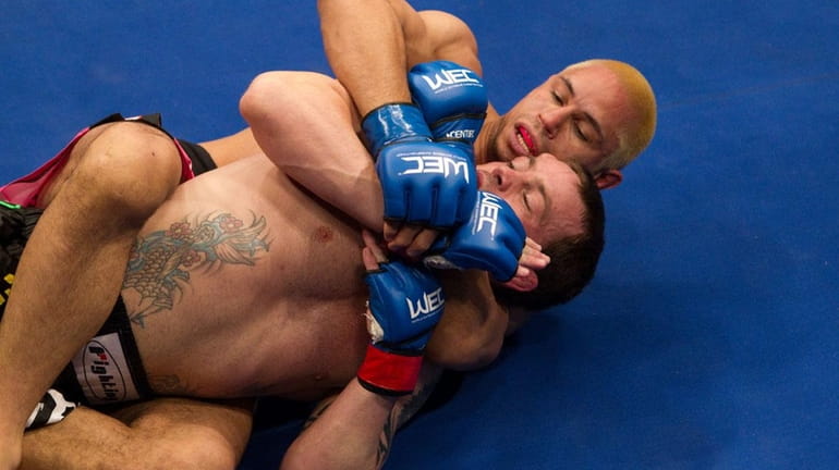 Jens Pulver, foreground, gets caught in a choke hold by...