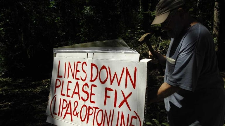 Jim Thoms installs a sign on his front property on...