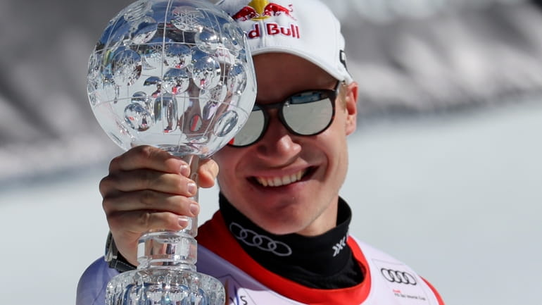 Switzerland's Marco Odermatt holds the World Cup super-g discipline trophy...