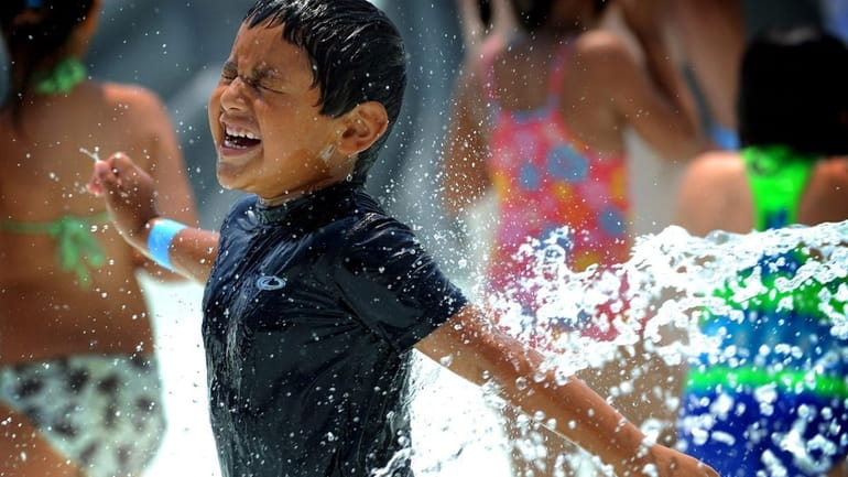 Matthew Bayes, 5, of Bay Shore, cools off in the...
