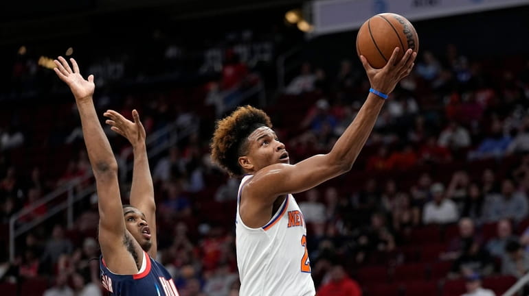 Knicks' Miles McBride, right, goes up for a shot as...