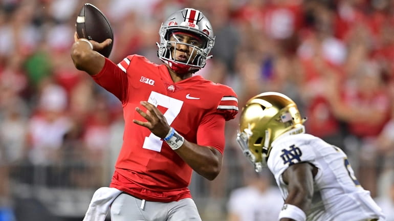 Ohio State quarterback C.J. Stroud throws while being pressured by...