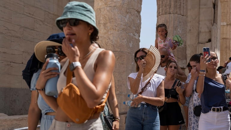 Tourists visit the ancient Acropolis hill during a heat wave...