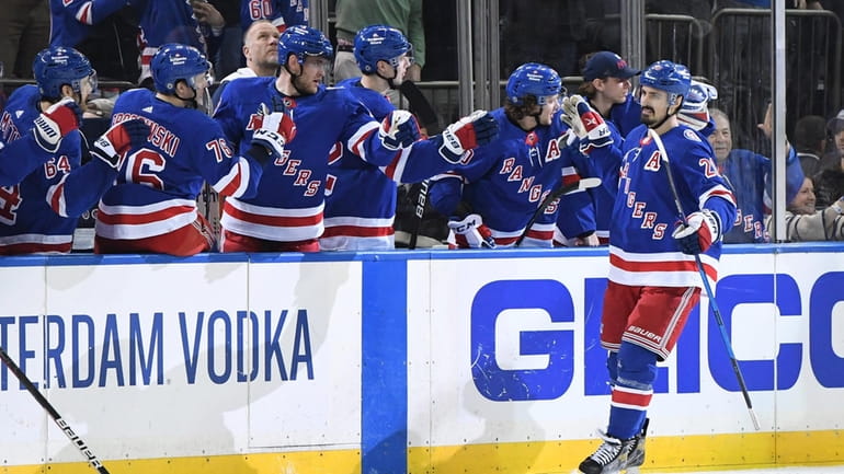 Rangers left wing Chris Kreider is greeted by teammates after...